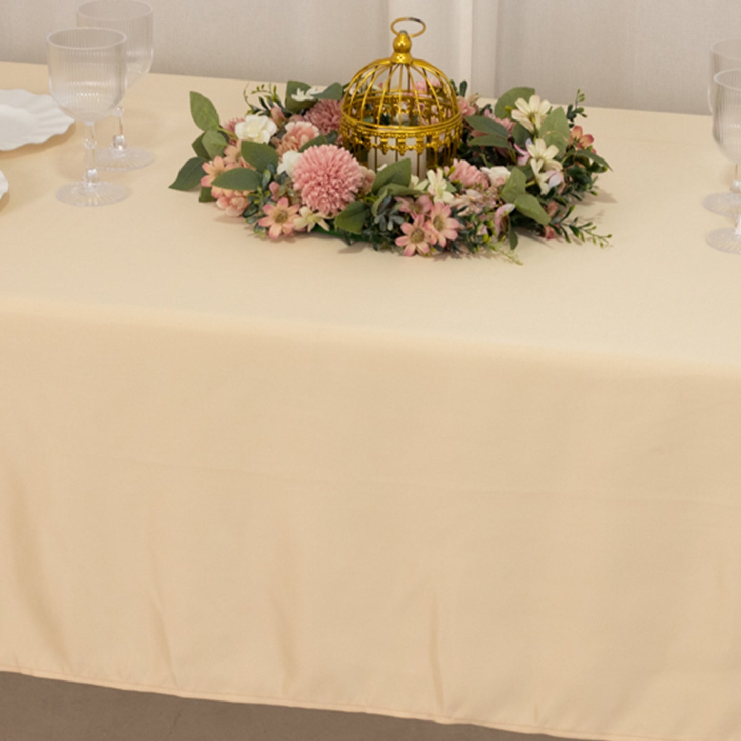 Beige Lamour satin rectangle tablecloth with floral centerpiece.