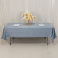 Dusty blue satin rectangle tablecloth on a table with floral centerpiece.