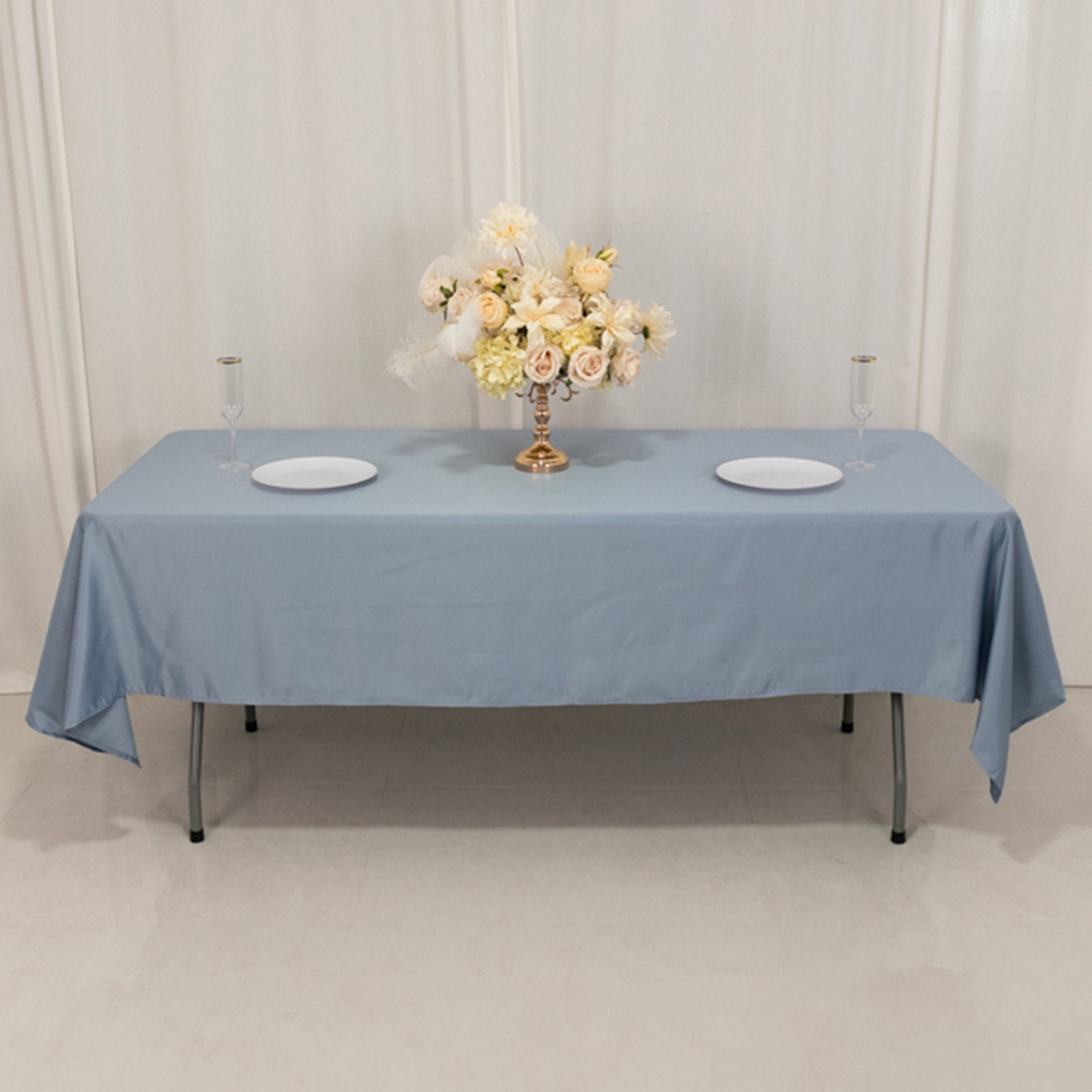Dusty blue satin rectangle tablecloth on a table with floral centerpiece.