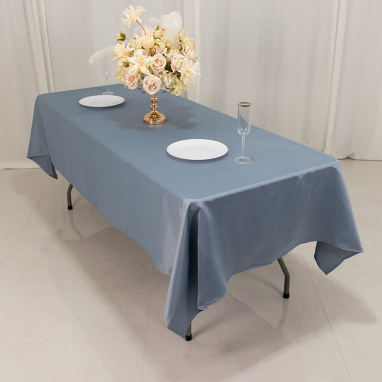 Dusty blue satin rectangle tablecloth on a dining table.