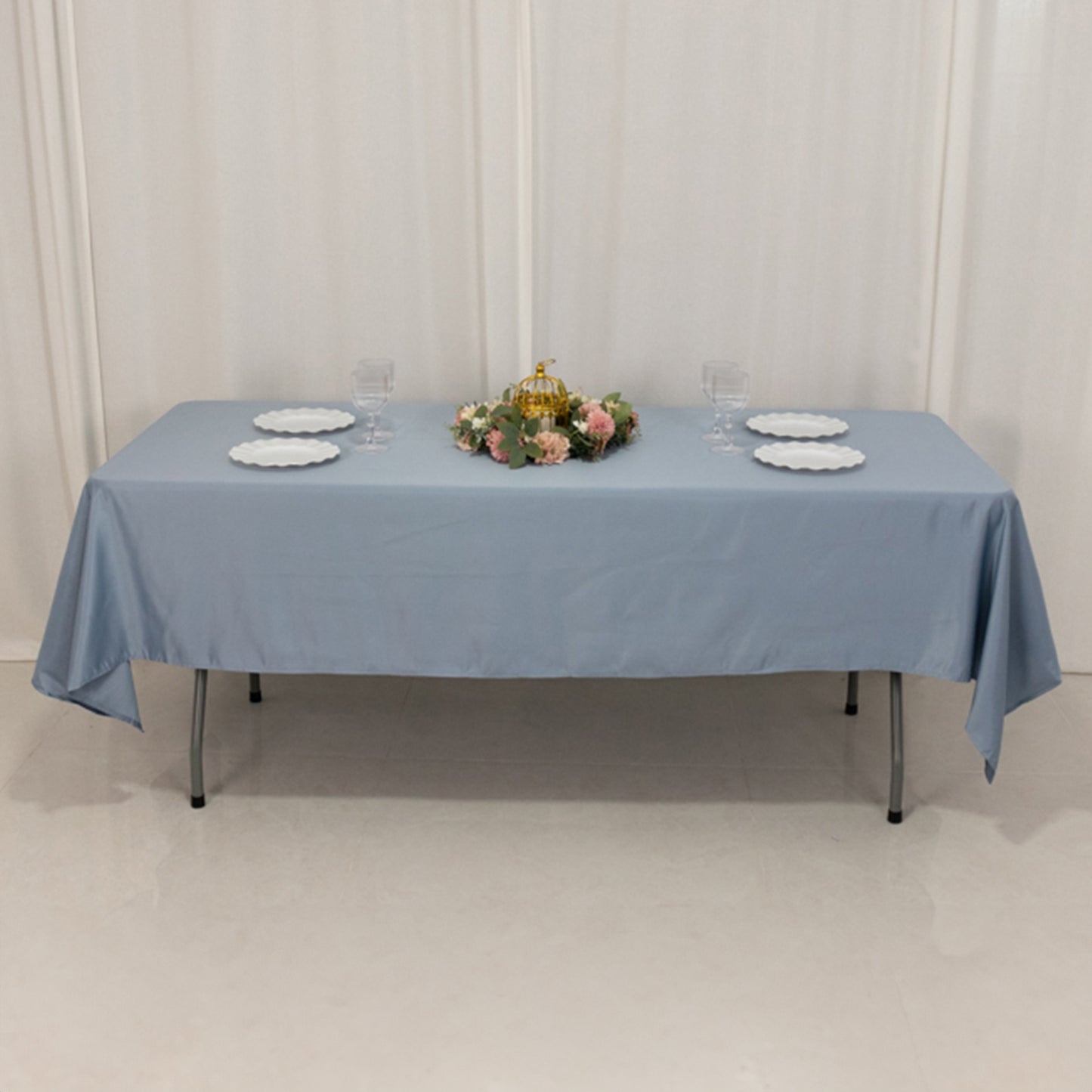Dusty blue satin rectangle tablecloth on a table set for dining.
