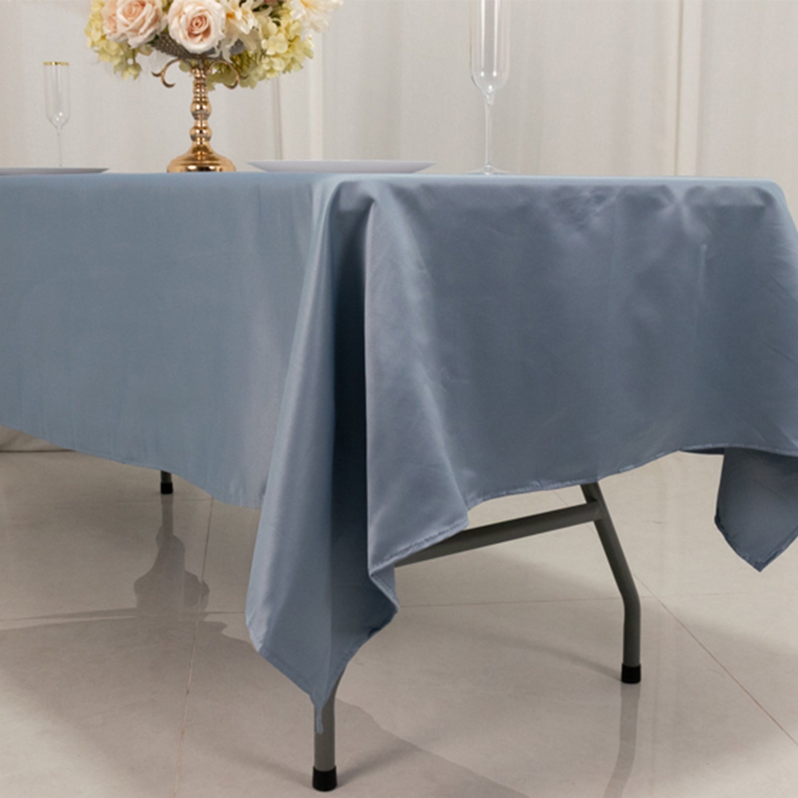 Dusty blue satin rectangle tablecloth on a dining table.