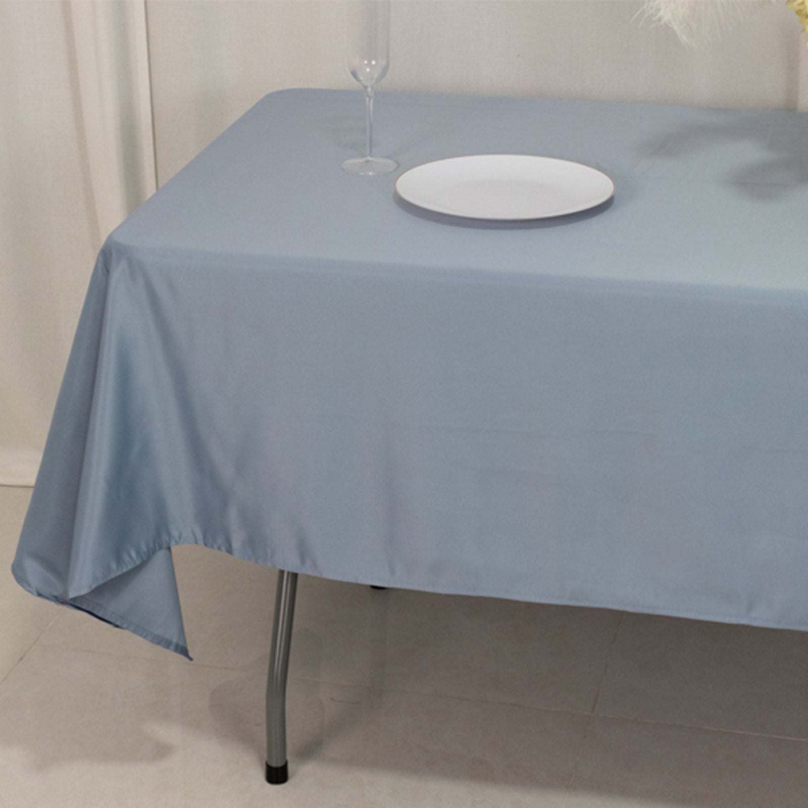 Dusty blue satin rectangle tablecloth on a dining table.