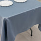 Dusty blue satin rectangle tablecloth on a table with white plates.