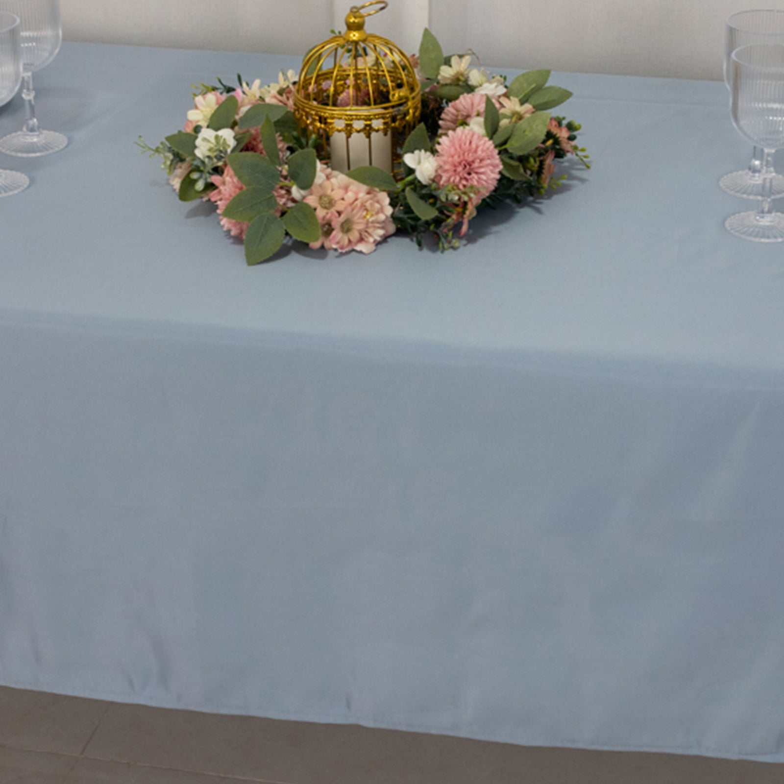Dusty blue satin rectangle tablecloth with floral centerpiece.