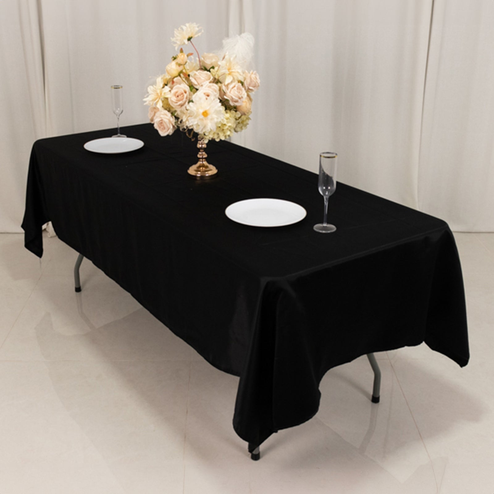 Black Lamour satin rectangle tablecloth on a table with floral centerpiece.