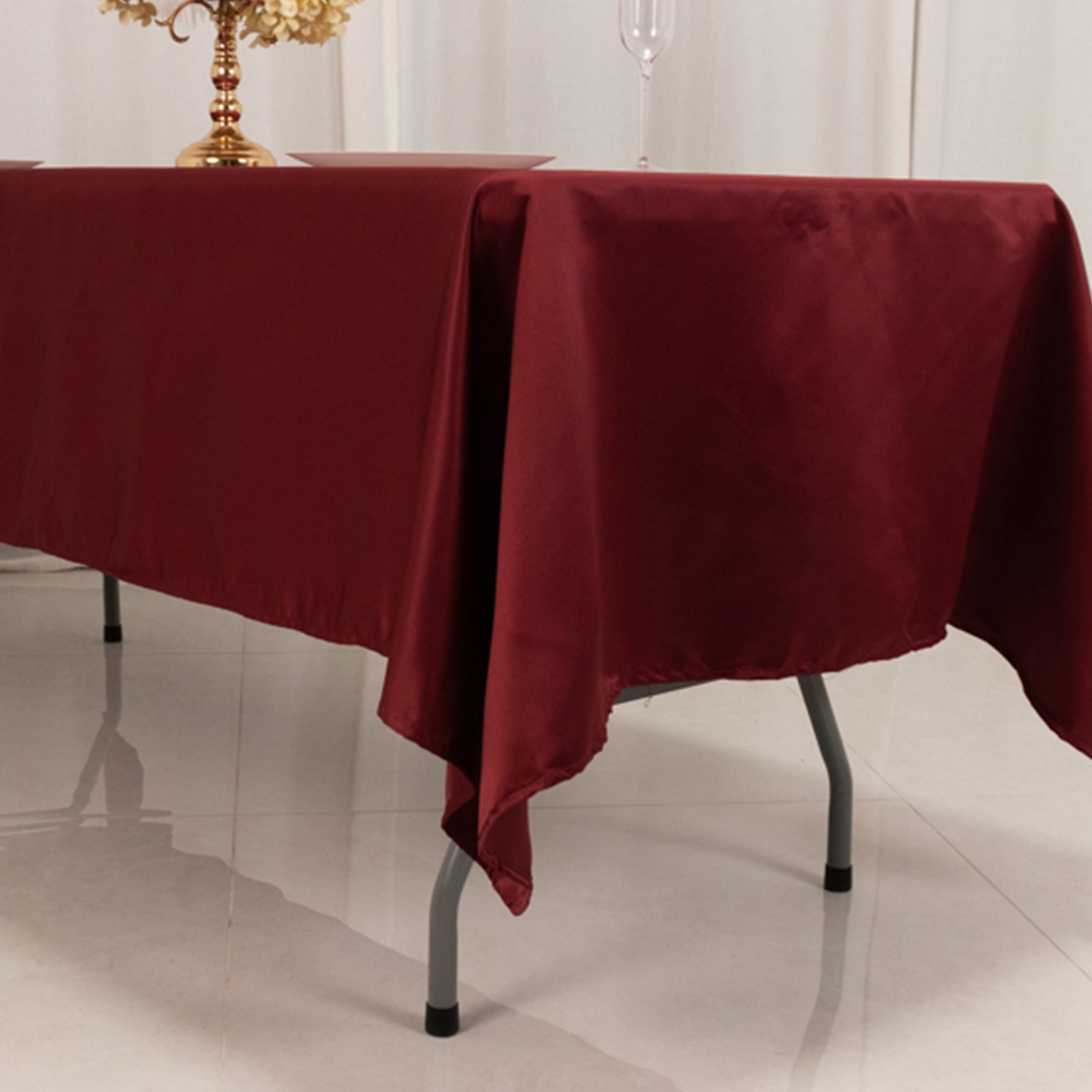 Burgundy satin rectangle tablecloth on a dining table.
