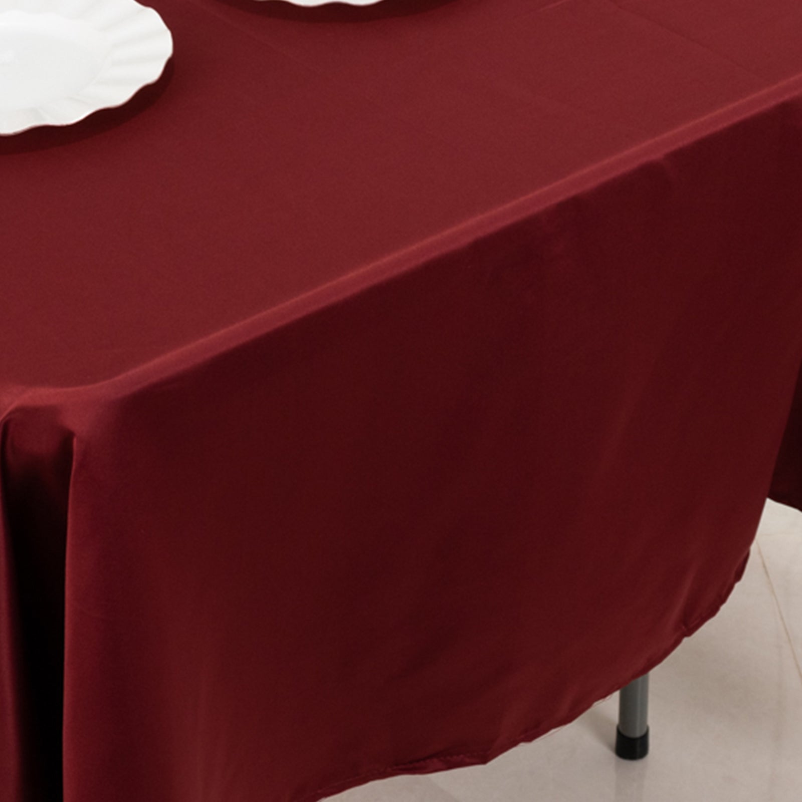 Burgundy satin rectangle tablecloth on a dining table.