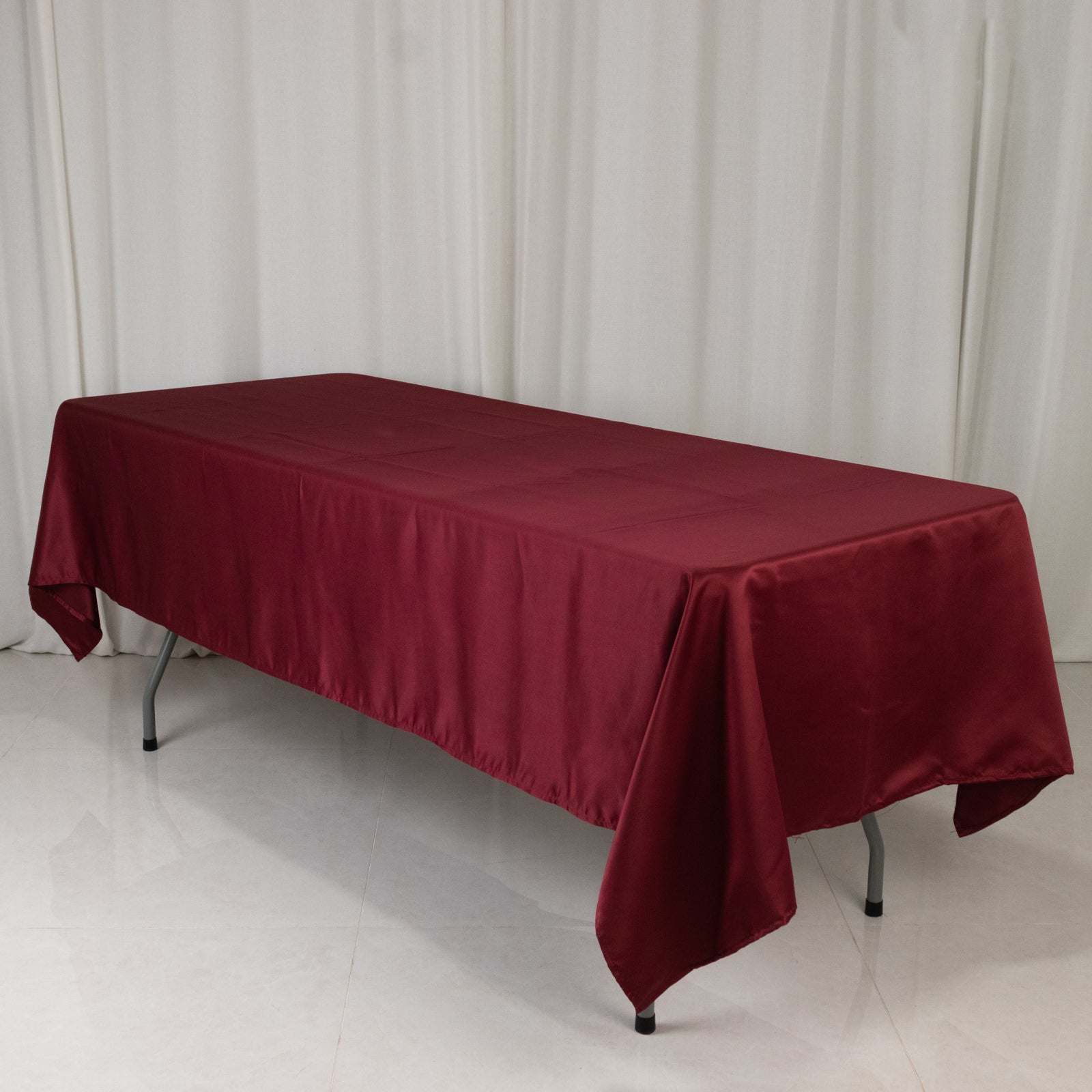 Burgundy satin rectangle tablecloth on a table.
