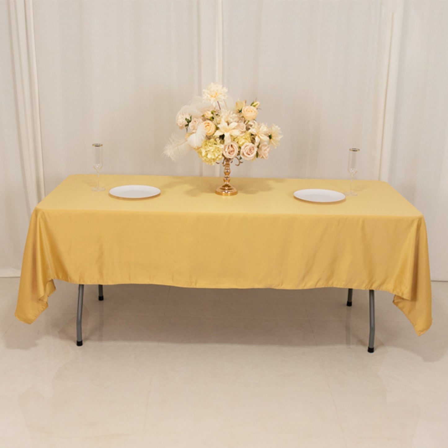 Champagne satin tablecloth on a table with floral centerpiece.