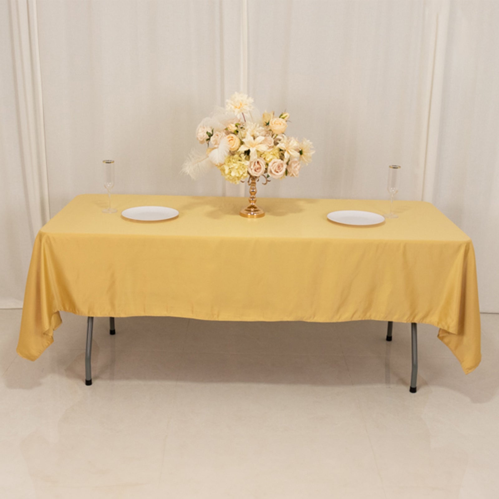 Champagne satin tablecloth on a table with floral centerpiece.