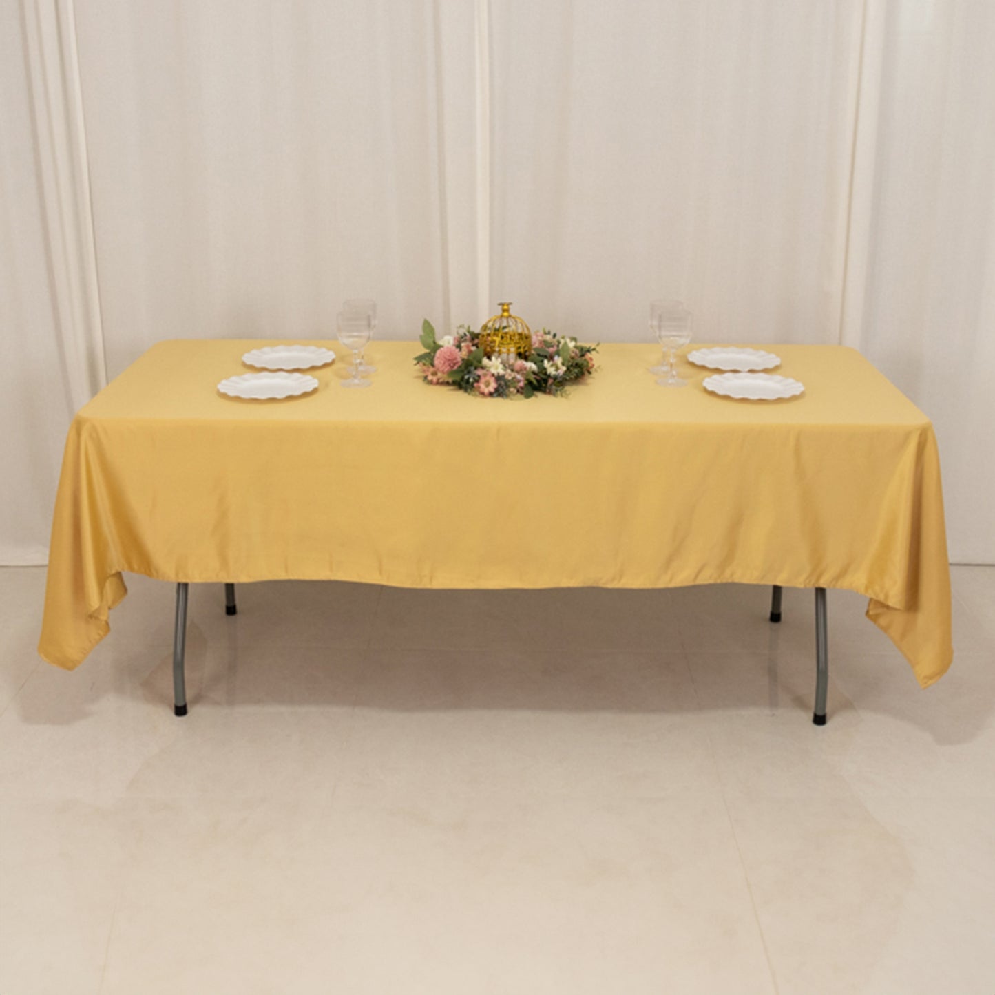 Champagne rectangular tablecloth with floral centerpiece and dinnerware.