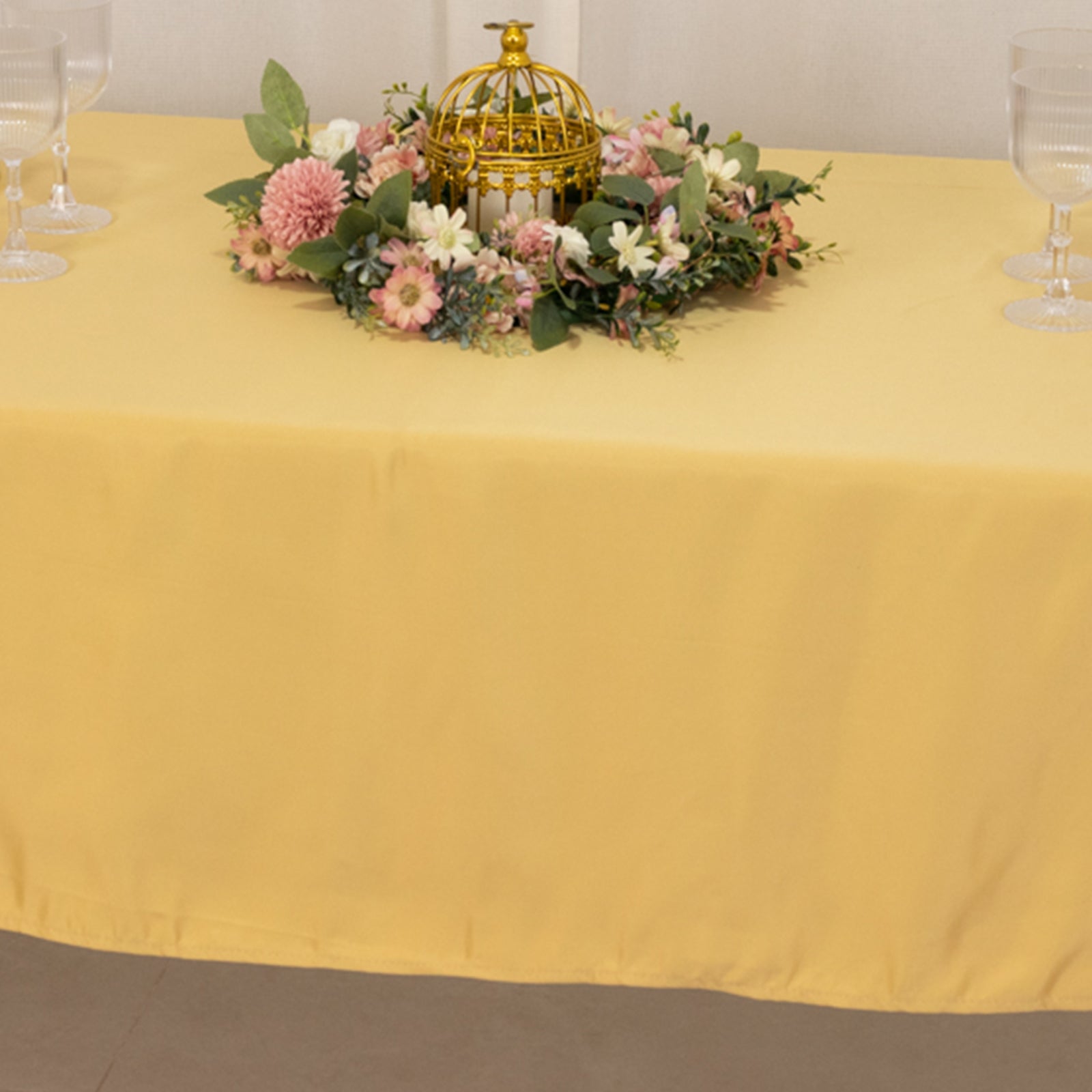 Champagne satin rectangle tablecloth on a decorated table.