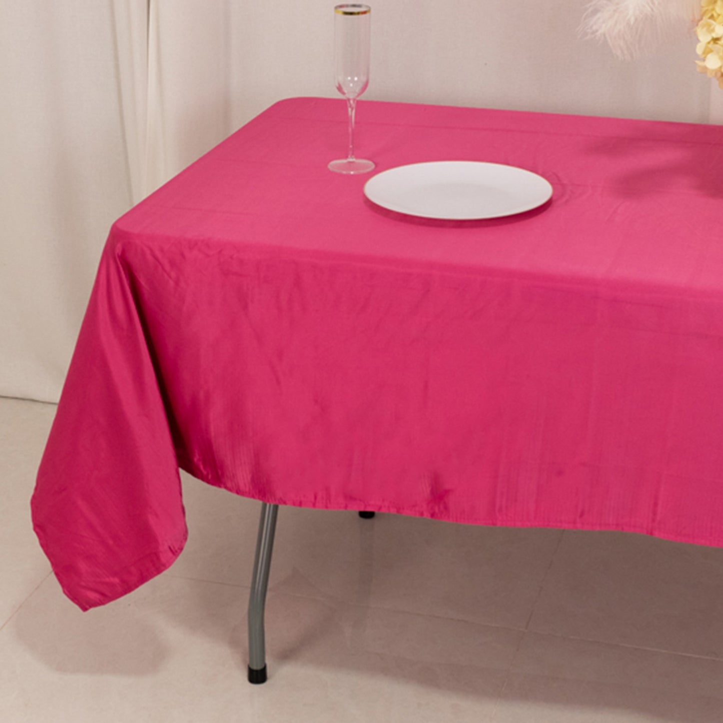 Fuchsia satin rectangle tablecloth on a dining table.