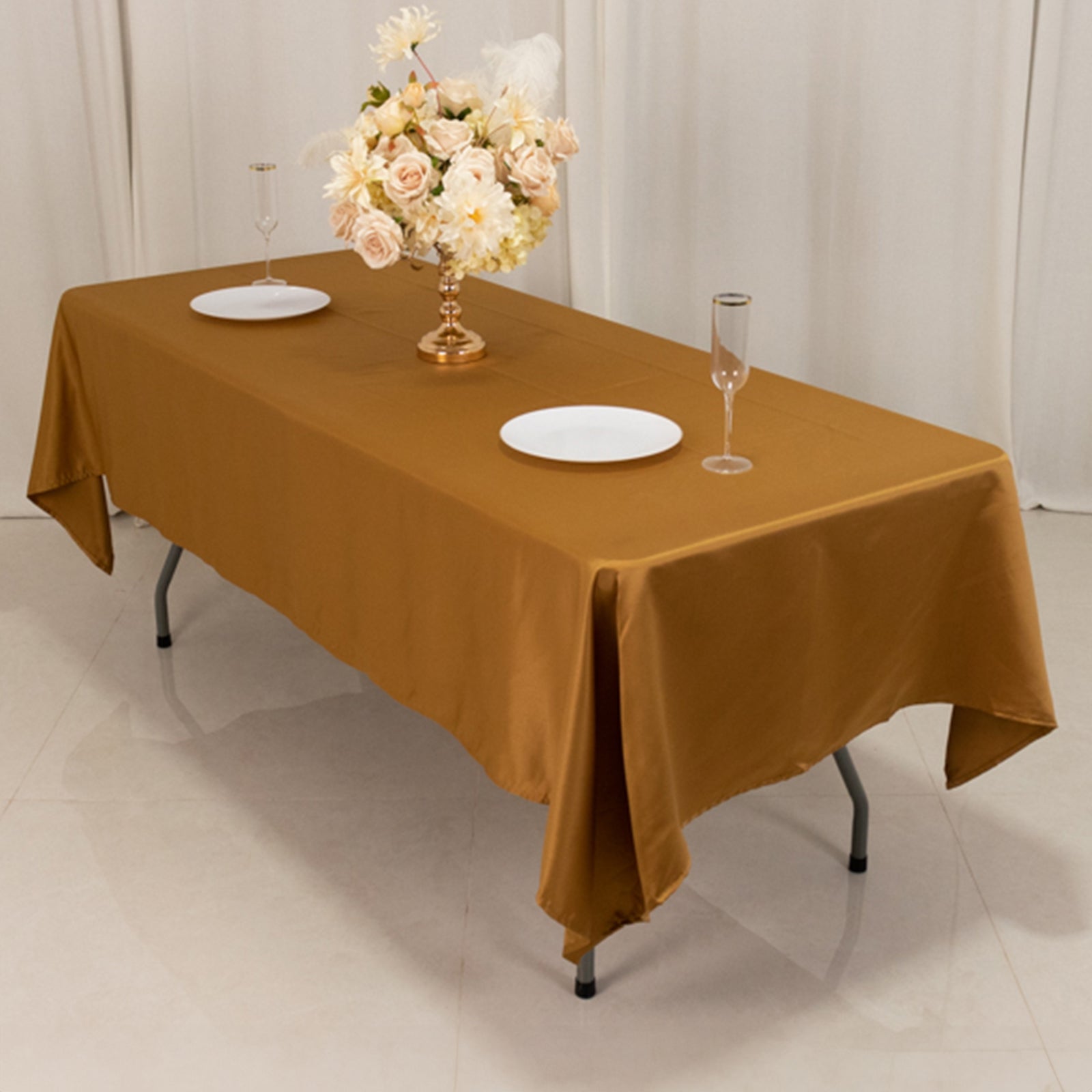 Gold Lamour satin rectangle tablecloth on a table with floral centerpiece.