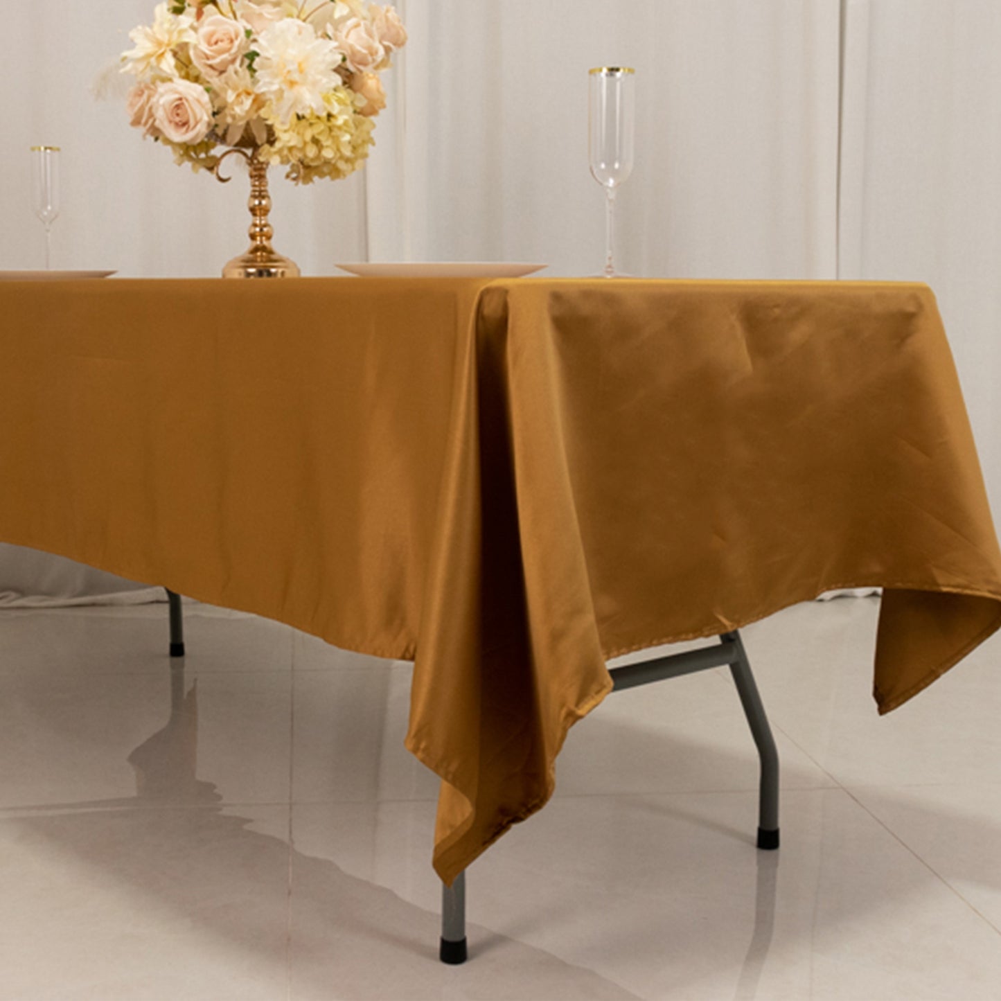 gold satin rectangle tablecloth on a table with a floral centerpiece