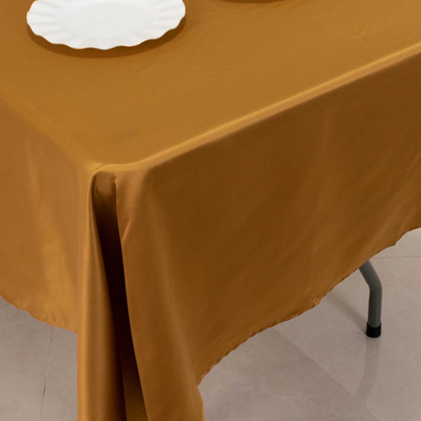 Gold satin rectangle tablecloth on a table.
