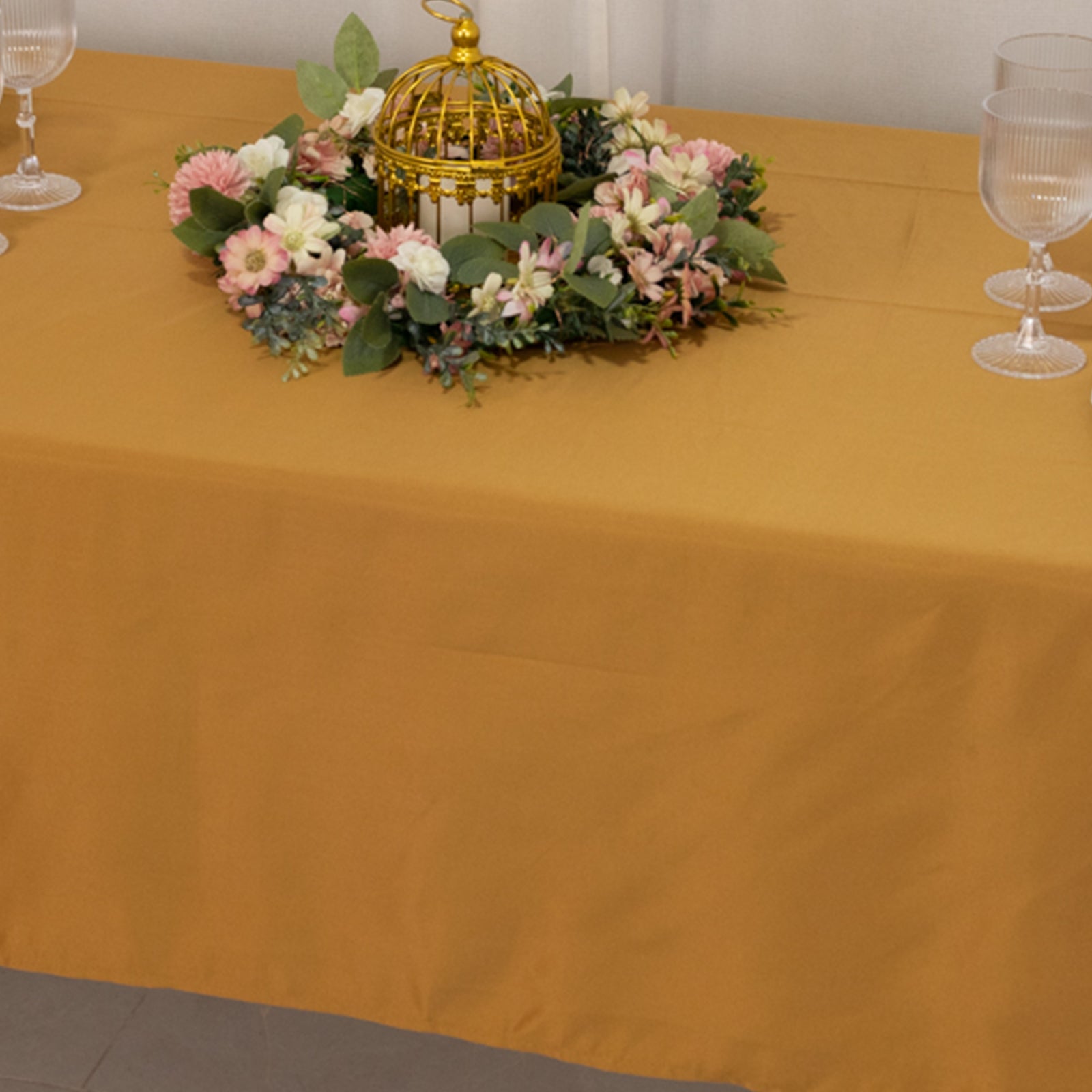 Gold satin rectangle tablecloth with floral centerpiece.