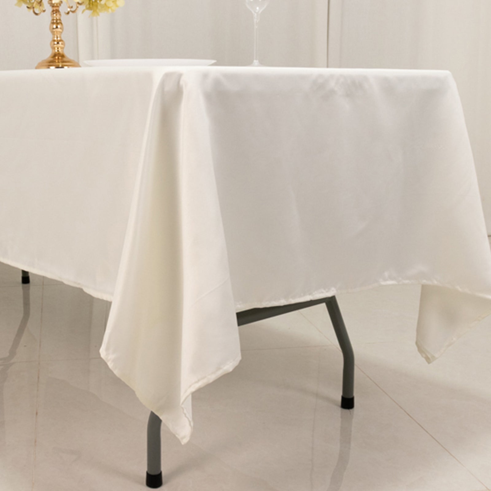 Ivory satin rectangle tablecloth on a dining table.
