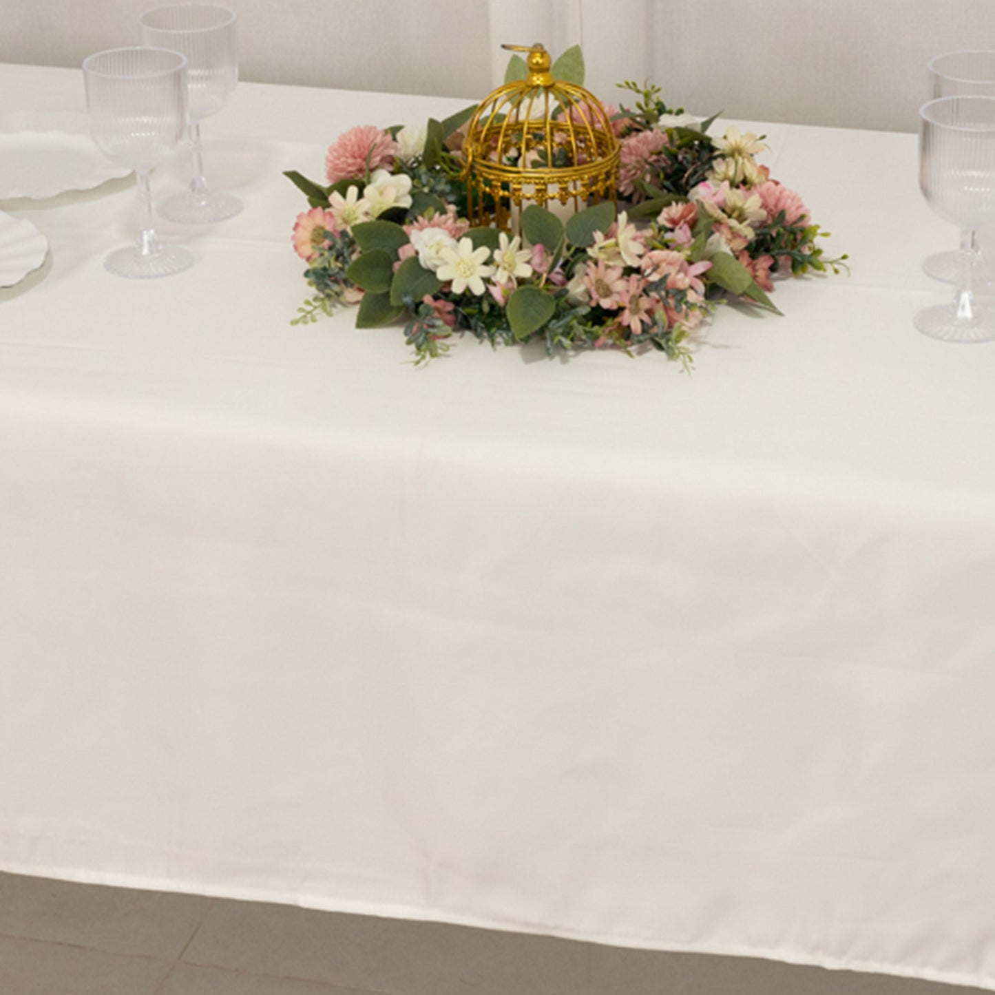 Ivory Lamour Satin Rectangle Tablecloth on a decorated table.