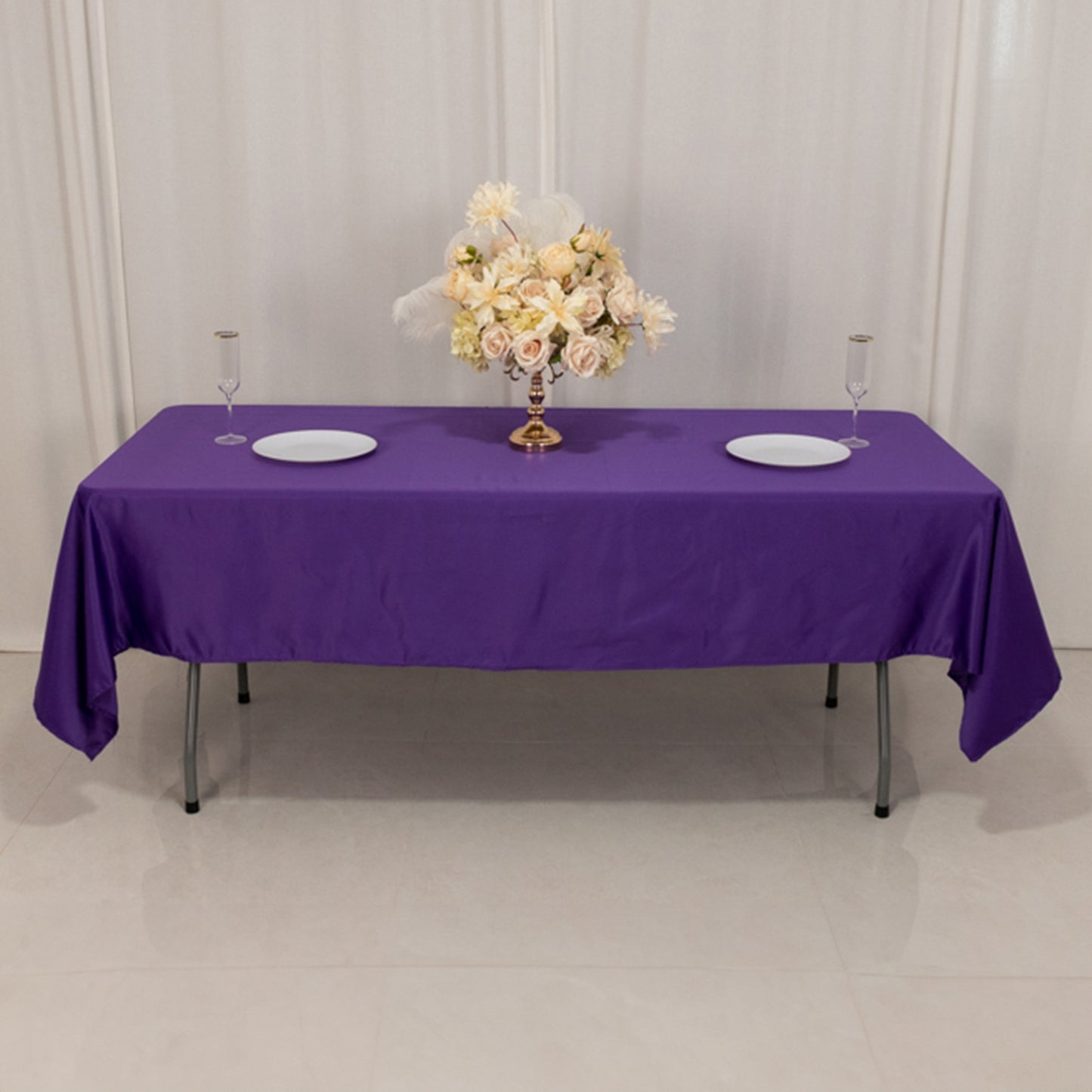 Purple satin rectangle tablecloth on a table with floral centerpiece.