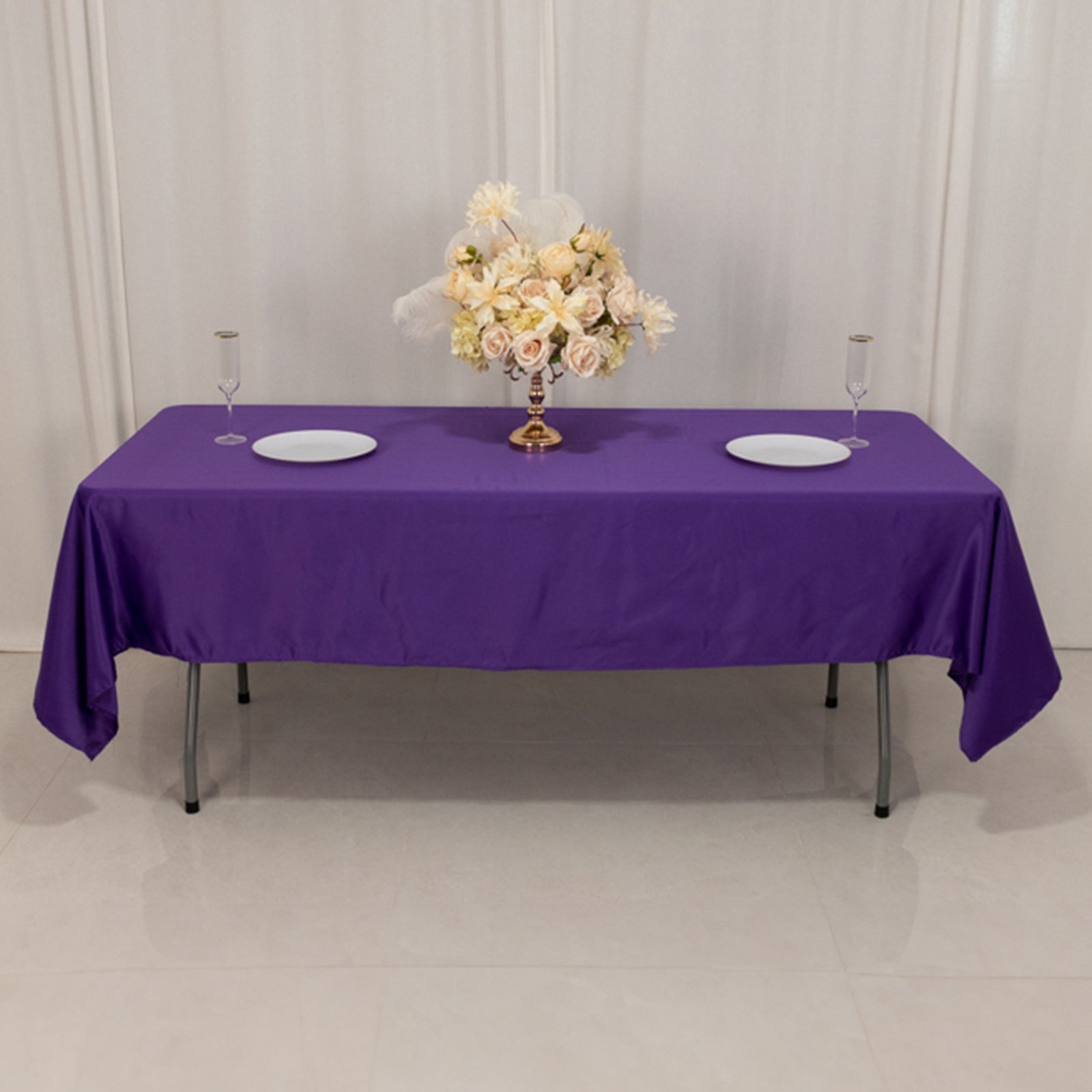 Purple satin rectangle tablecloth on a table with floral centerpiece.