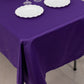 Purple satin tablecloth on a dining table with white plates.