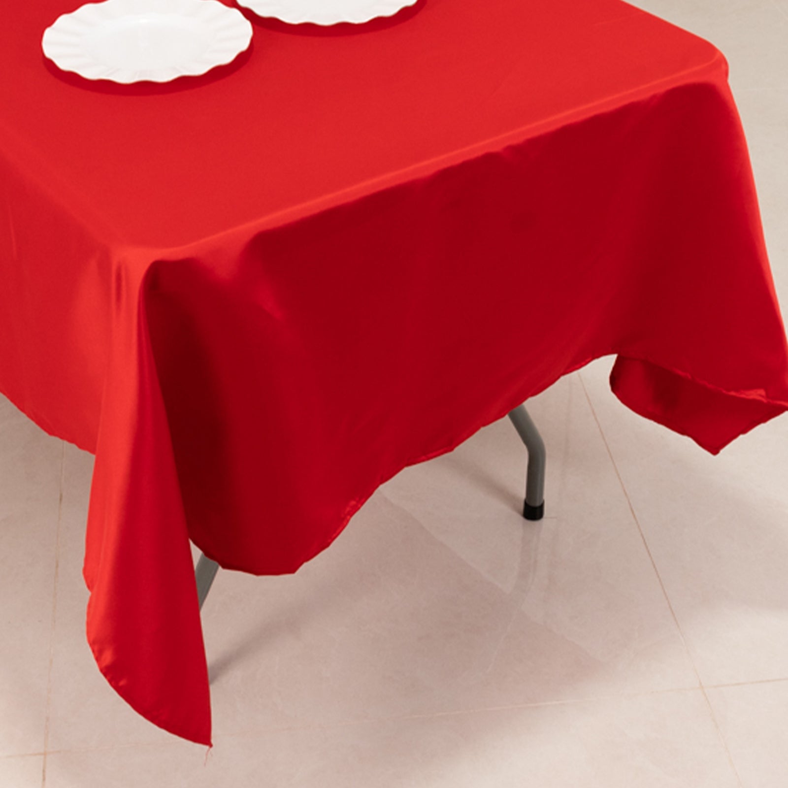 Red satin rectangle tablecloth on a table.