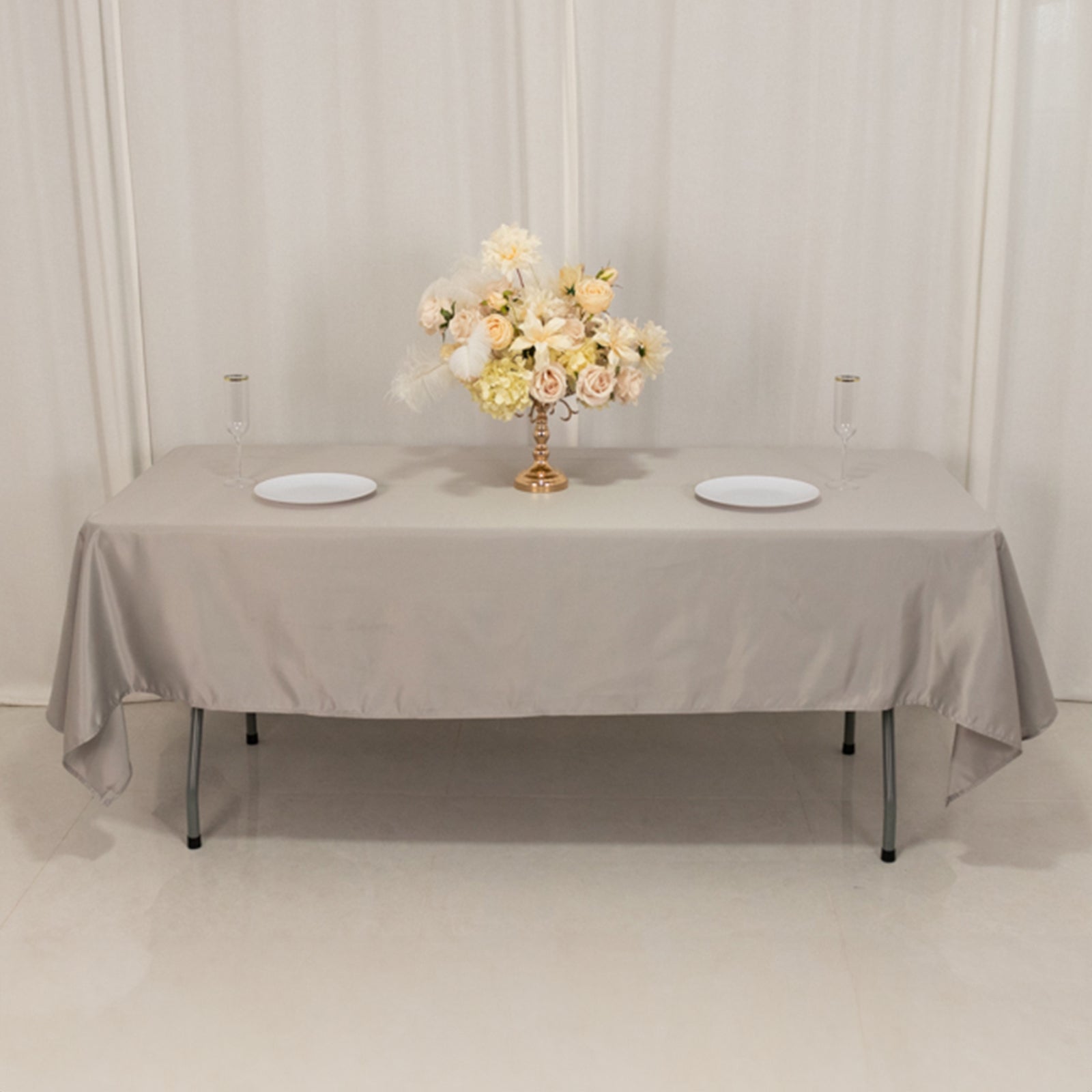 Silver satin rectangle tablecloth with a floral centerpiece.