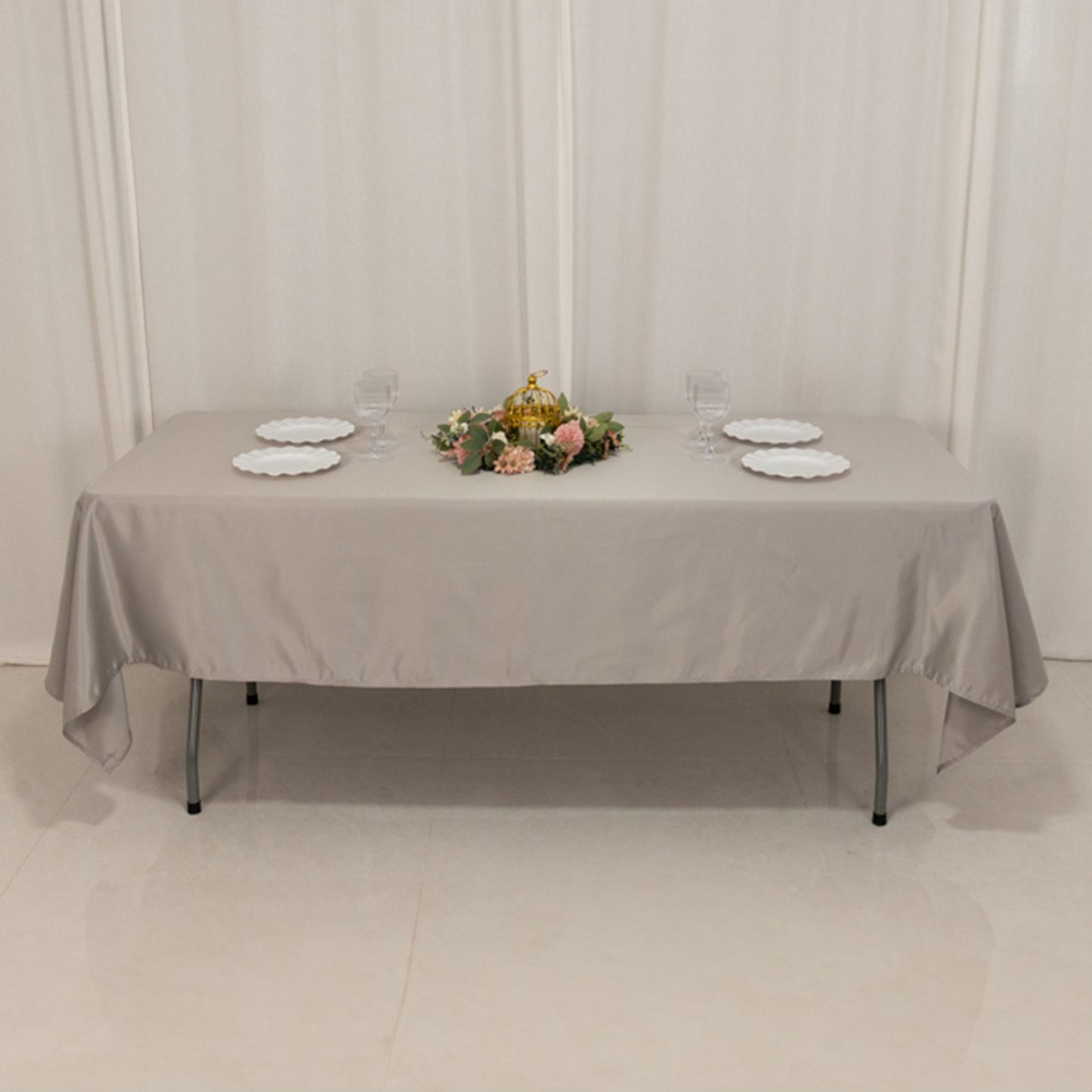 Silver satin rectangle tablecloth on a table with floral centerpiece.