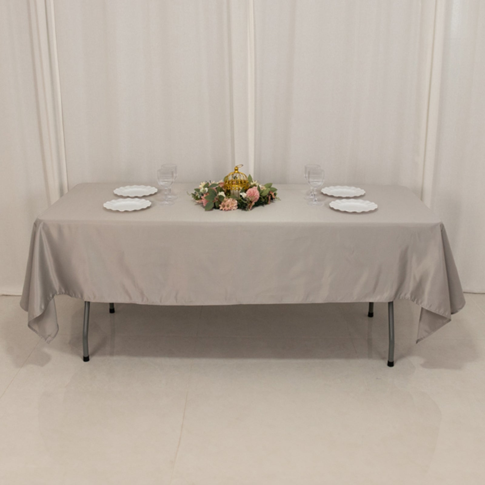 Silver satin rectangle tablecloth on a table with floral centerpiece.