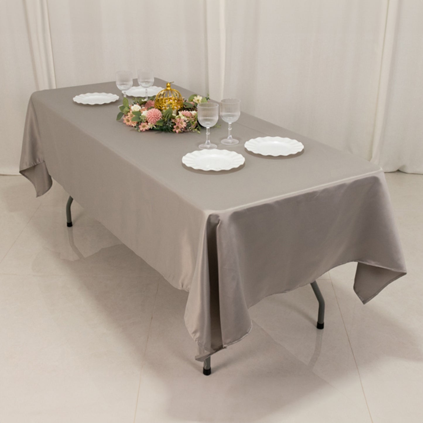 Silver satin rectangle tablecloth on a dining table with decorative elements.
