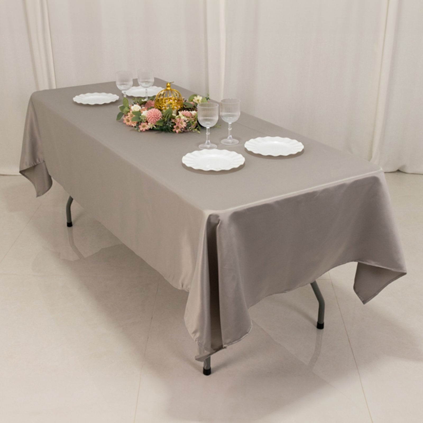 Silver satin rectangle tablecloth on a dining table with decorative elements.