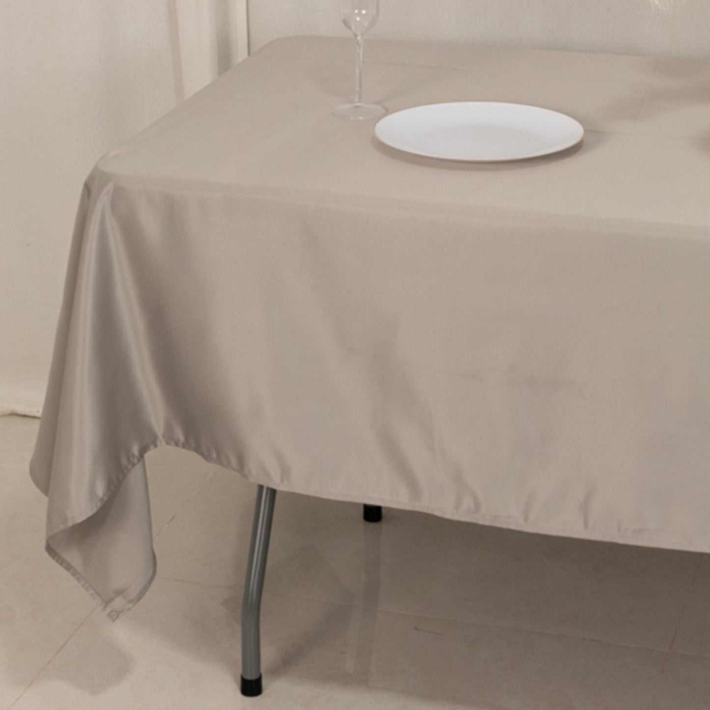 Silver satin rectangle tablecloth on a dining table.