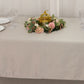 Silver rectangle tablecloth on a dining table with floral centerpiece.