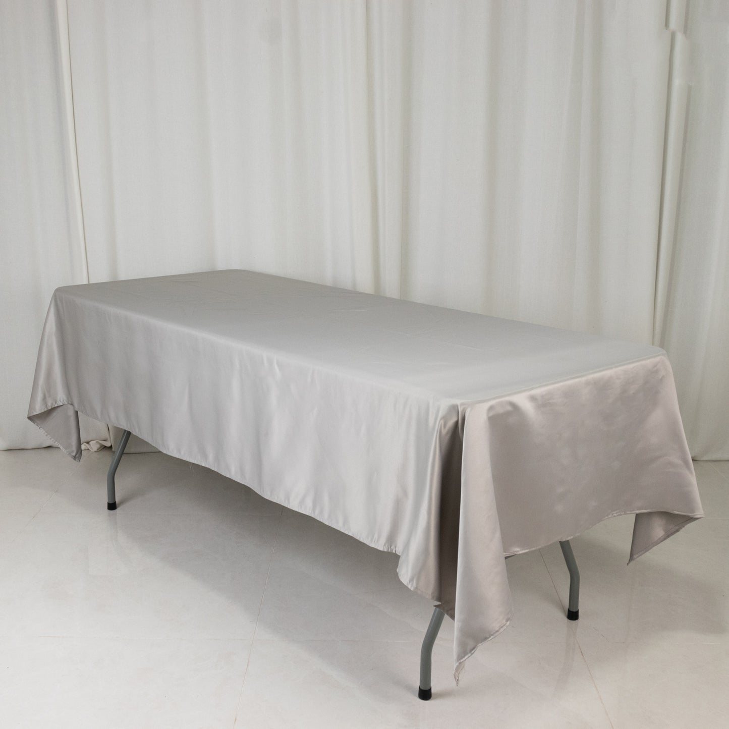 Silver rectangular satin tablecloth on a table.