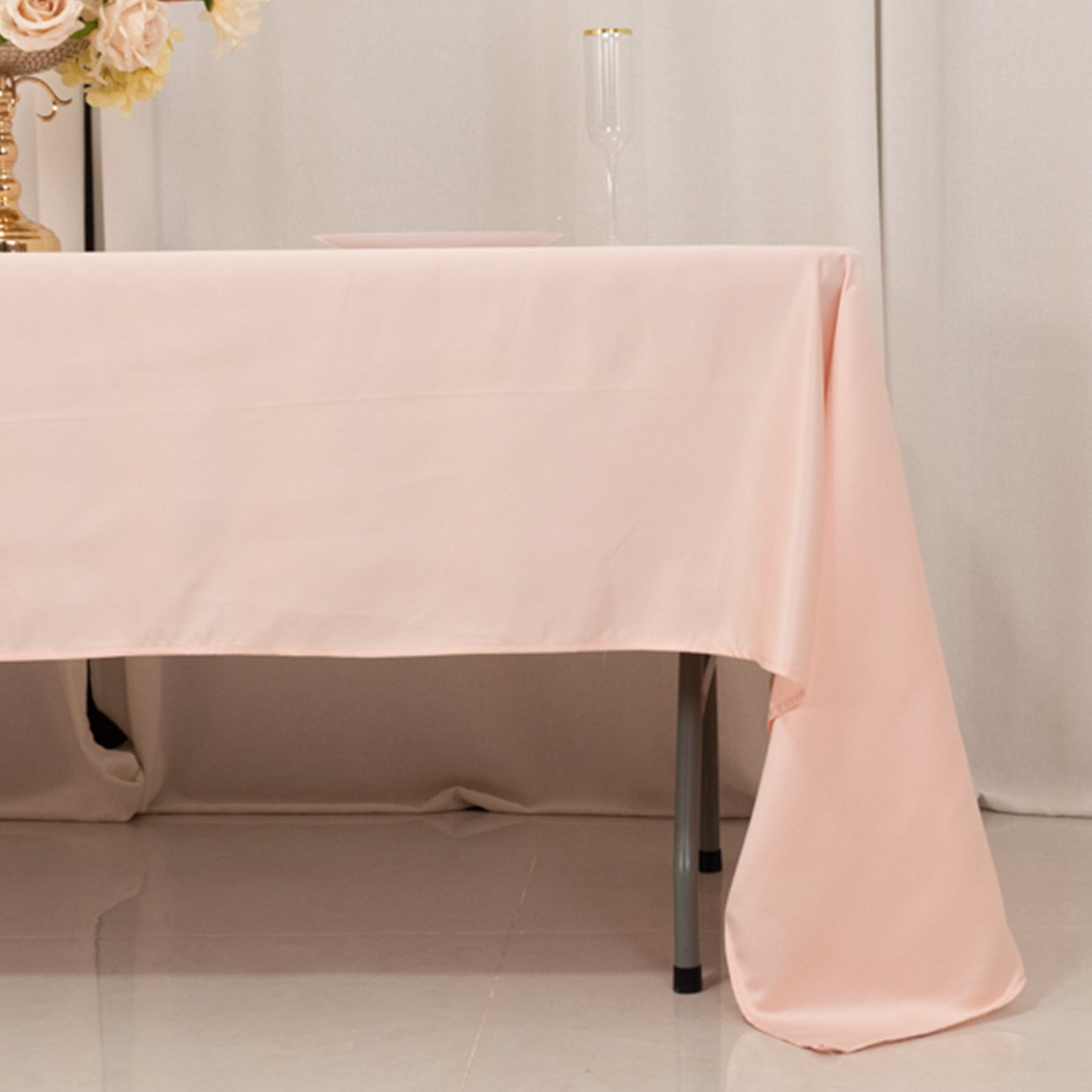 Blush satin rectangle tablecloth draping elegantly over a table.