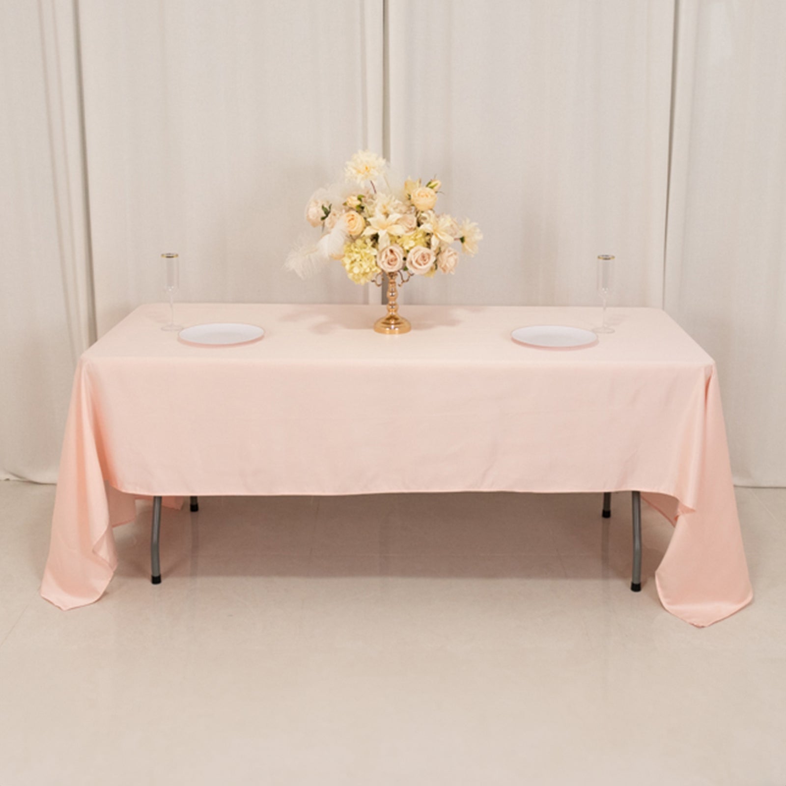 Blush satin rectangle tablecloth on a table with floral arrangement.