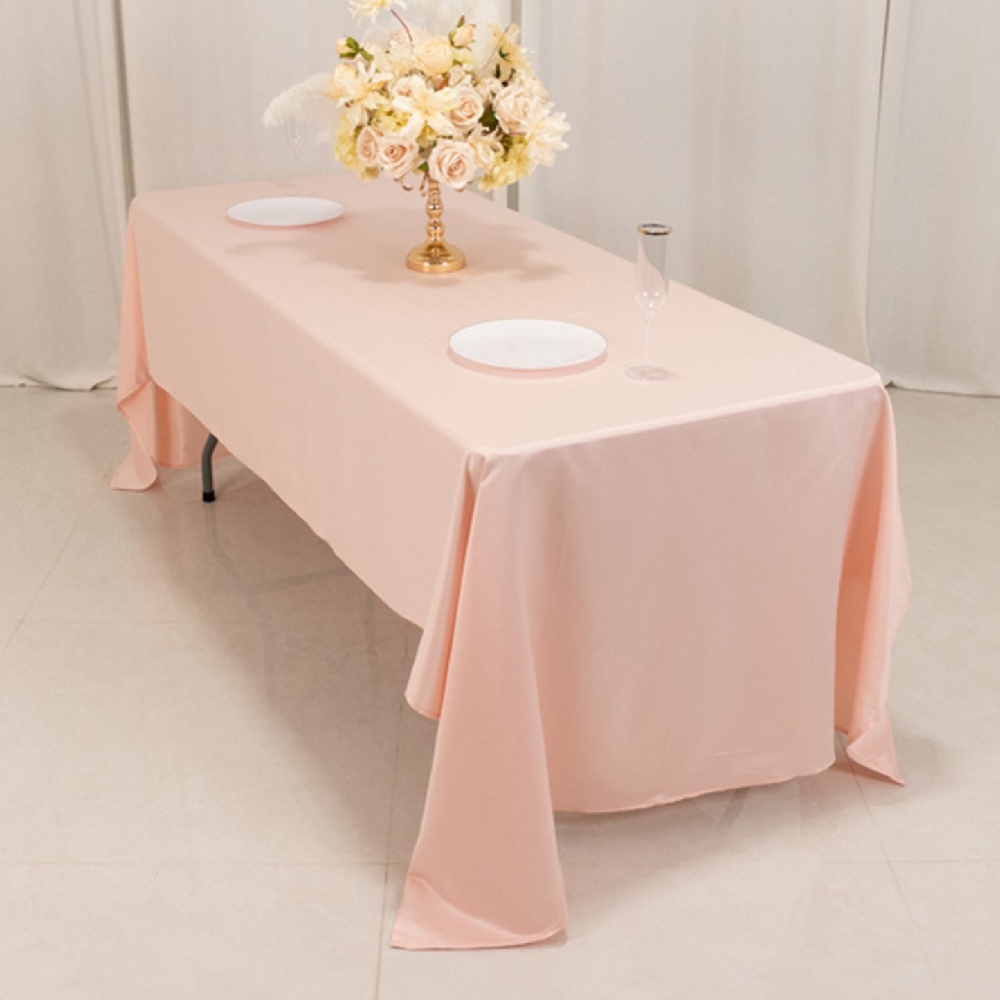 Blush satin rectangle tablecloth on a table with floral centerpiece.