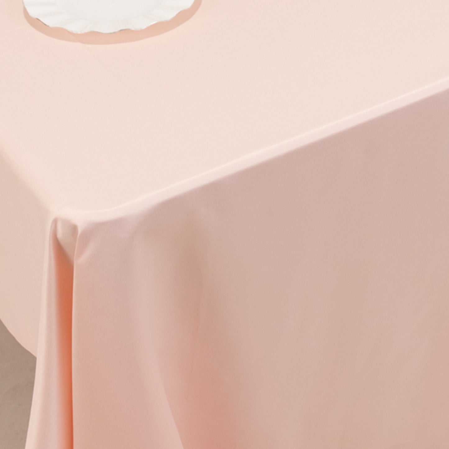 Blush satin rectangle tablecloth draped over a table.