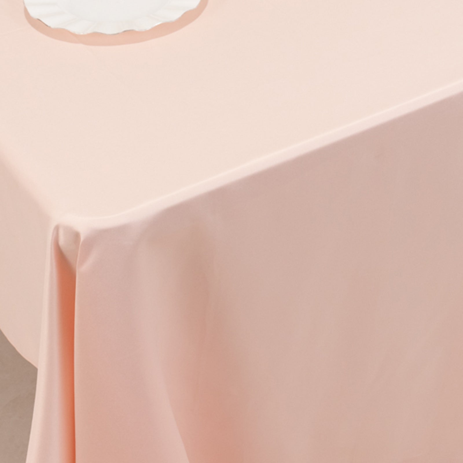 Blush satin rectangle tablecloth draped over a table.