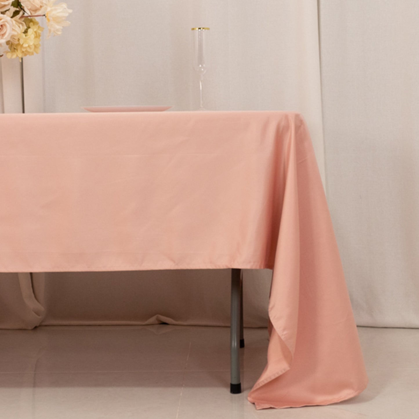 Dusty rose satin rectangle tablecloth on a table.