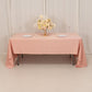 Dusty rose satin rectangle tablecloth on a table with floral centerpiece.