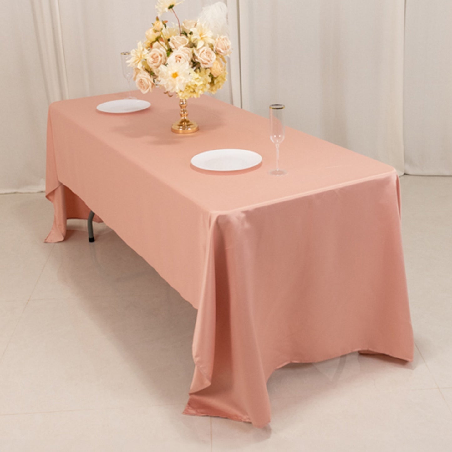 Dusty rose satin rectangle tablecloth on a dining table.