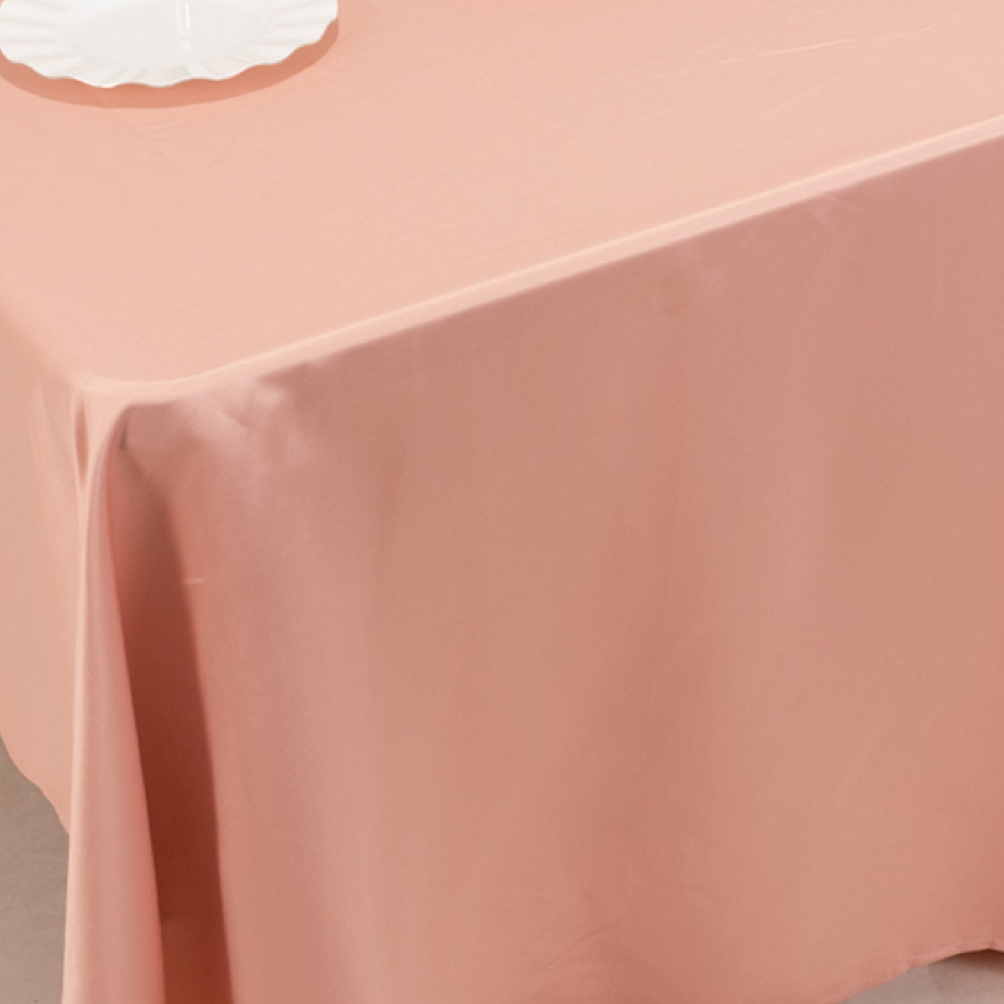 Dusty rose satin rectangle tablecloth on a table.
