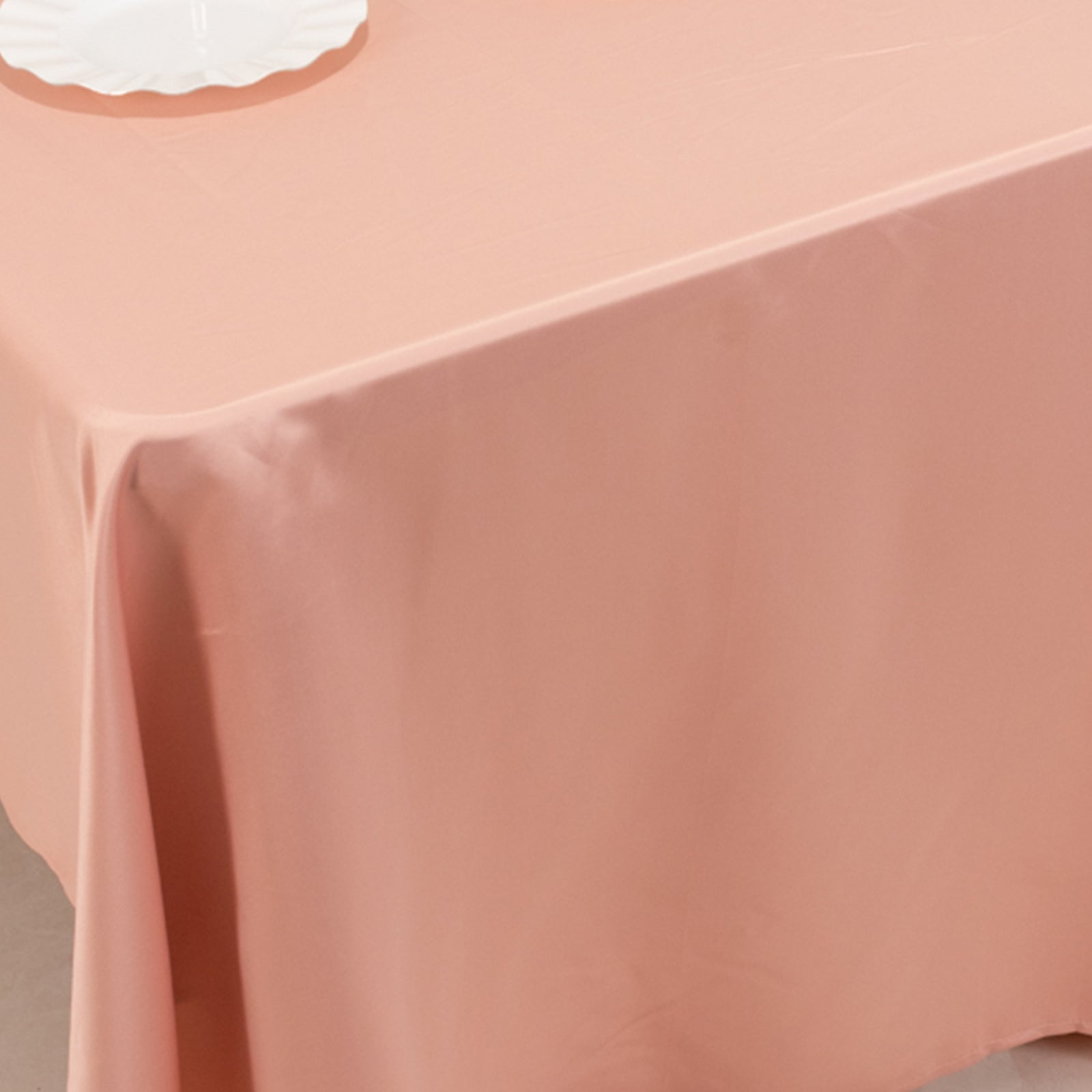 Dusty rose satin rectangle tablecloth on a table.