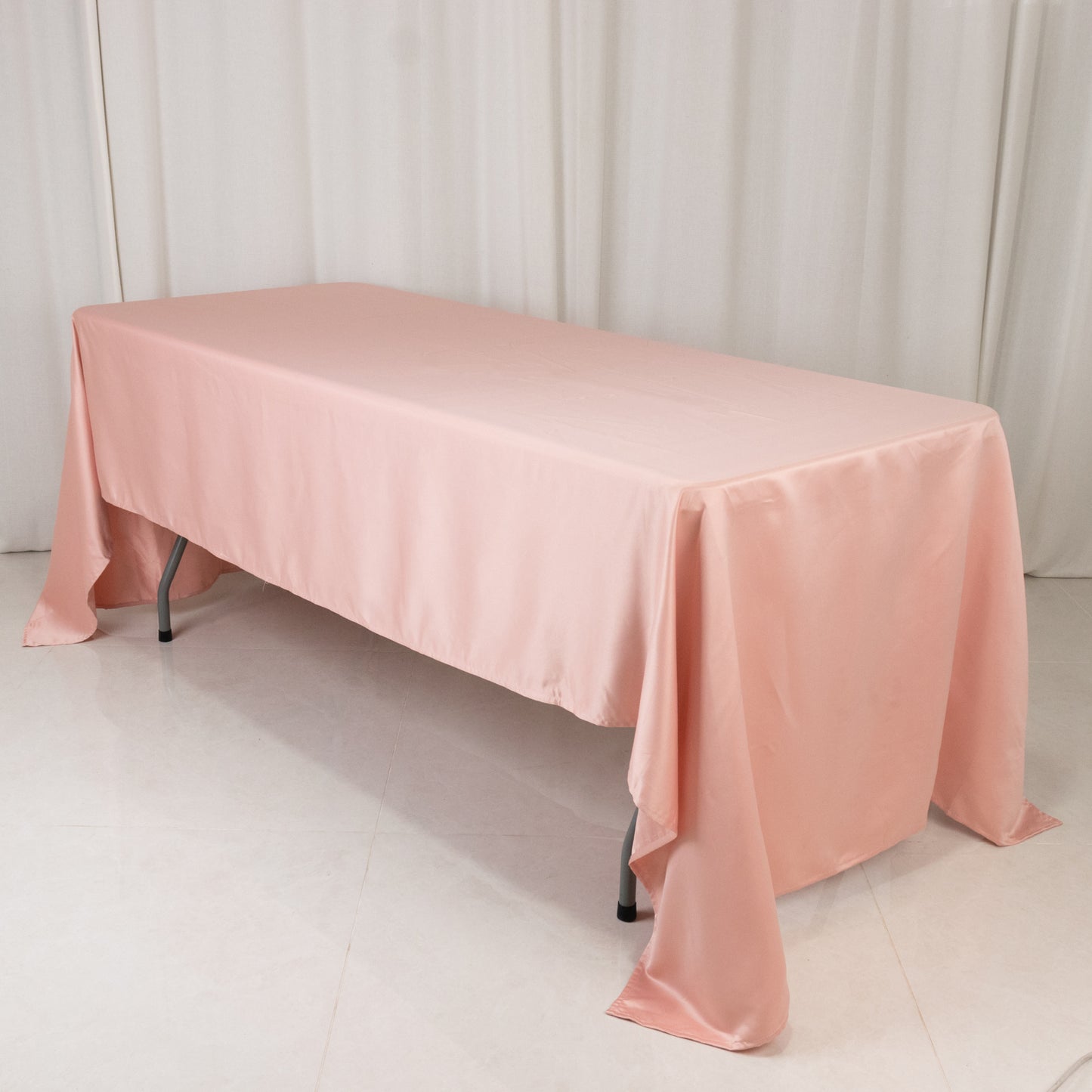 Dusty rose satin rectangle tablecloth for elegant dining settings.