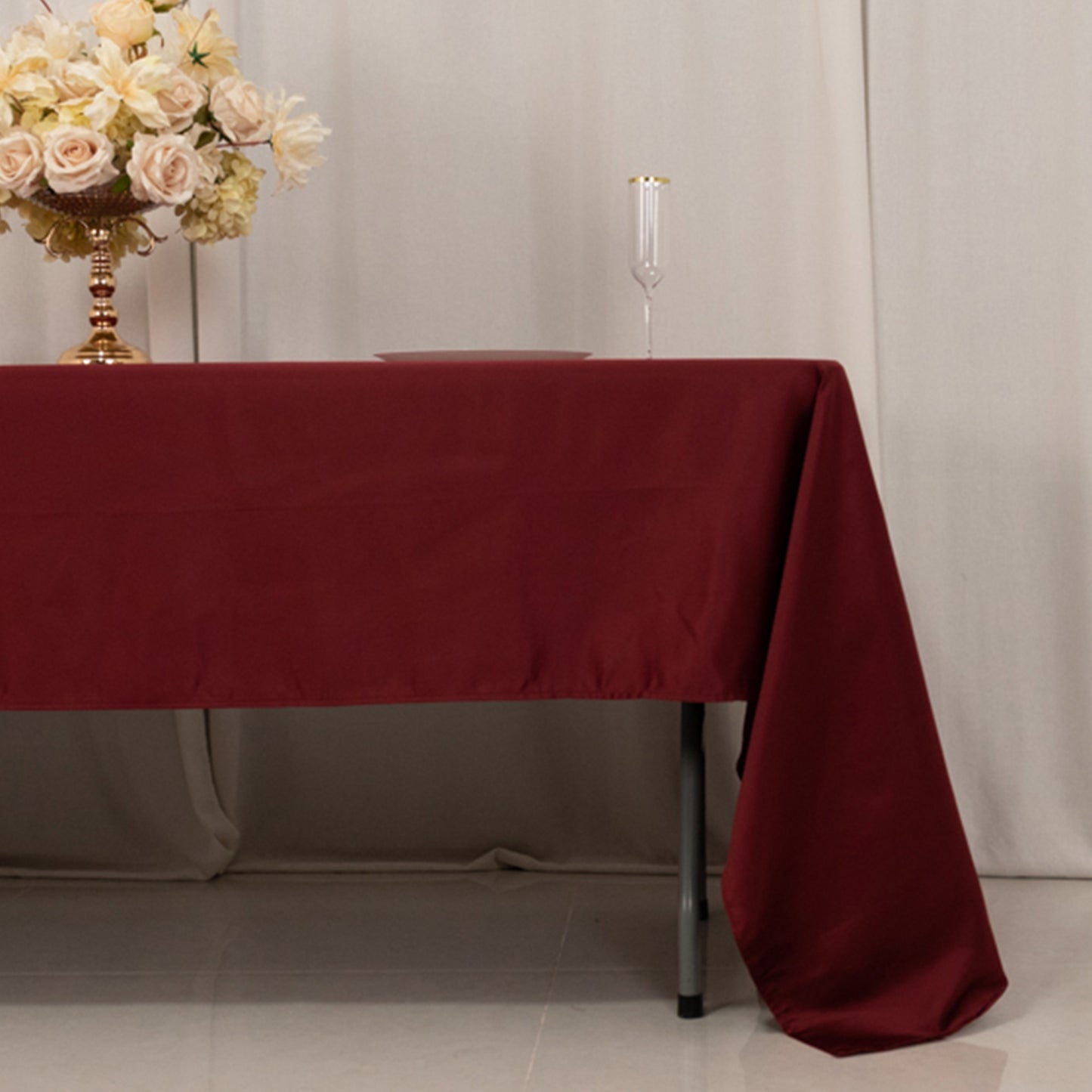 Burgundy Lamour Satin Rectangle Tablecloth on a table.