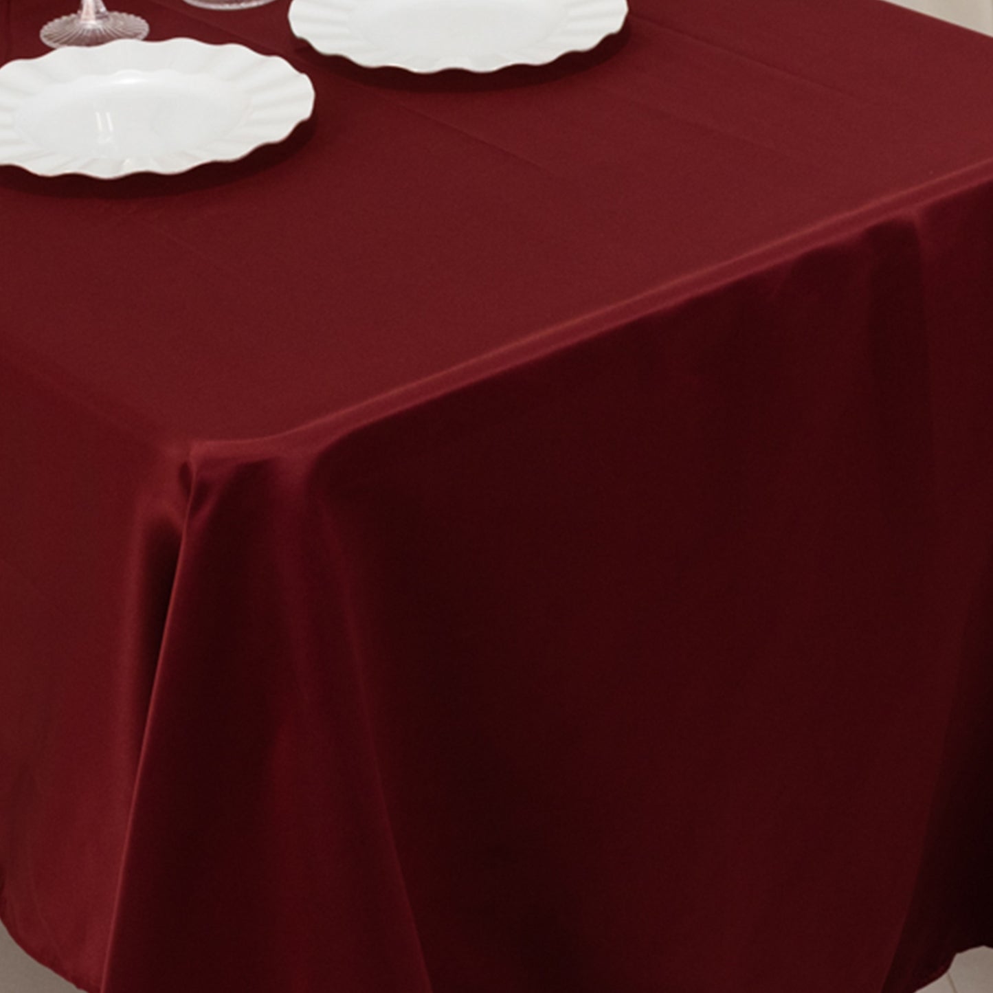Burgundy Lamour Satin Rectangle Tablecloth on a dining table.