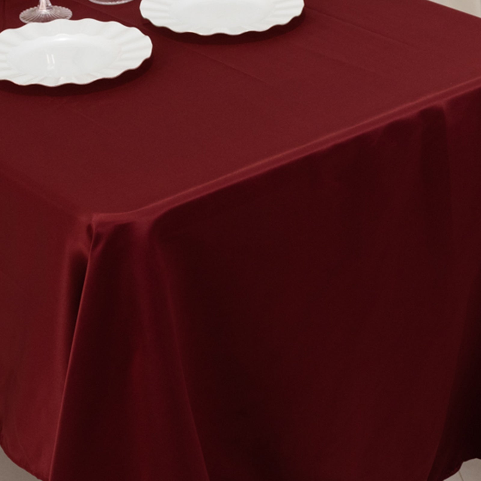 Burgundy Lamour Satin Rectangle Tablecloth on a dining table.